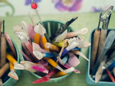 Outils de l'artiste céramique. Vue de dessus des piles, pétoncles, crayons et brosses qui sont situés dans une tasse spéciale.