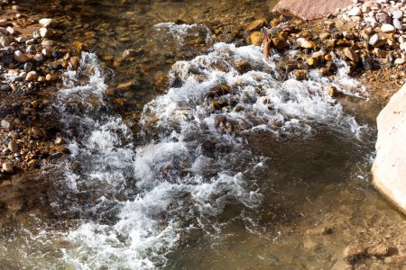 El río Virgin fluye a través de grandes rocas y los empinados cañones cerca de los estrechos en un día soleado de otoño en el Parque Nacional Zion, Utah.