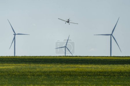 Photo for Prairie Crop Dusting near Saskatchewan Wind Farm - Royalty Free Image