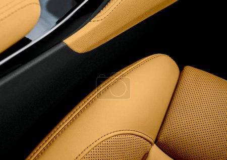 Modernes Luxusauto mit braunem Lederinterieur. Ein Teil der Details des perforierten Autositzes aus Leder. Braun perforiertes Leder Textur Hintergrund. Textur, Kunstleder mit Nähten. Lochledersitze