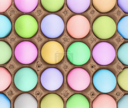 Easter eggs in wooden box texture background. Rainbow colored Easter eggs pattern. Group of easter eggs in a row. 