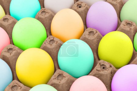 Easter eggs in wooden box texture background. Rainbow colored Easter eggs pattern. Group of easter eggs in a row.