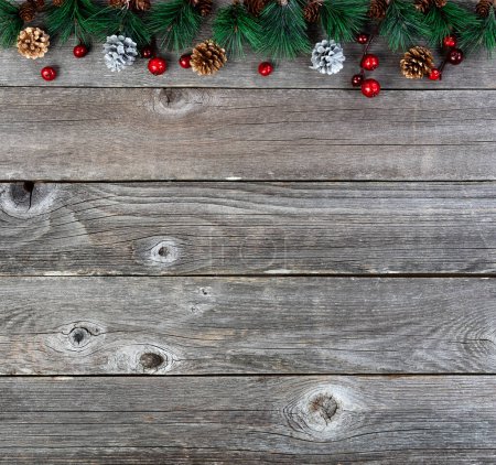 Foto de Feliz Navidad o feliz año nuevo fondo con ramas de abeto y conos de pino de plata de oro en tablas de madera rústica - Imagen libre de derechos