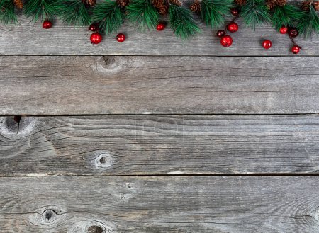 Photo for Merry Christmas or happy New Year background with fir tip tree branches and red berries on rustic wood boards - Royalty Free Image