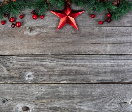 Téléchargez les photos : Joyeux Noël ou joyeux Nouvel An avec branches de pointe de sapin et décoration en étoile rouge sur des planches de bois rustiques - en image libre de droit