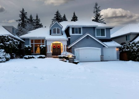 Photo for Front view of residential home decorated for Christmas and New Year holidays with fresh blanket of snow - Royalty Free Image