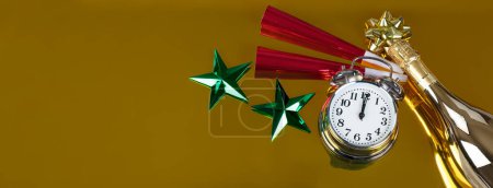 Téléchargez les photos : Horloge sonne minuit pour la célébration du Nouvel An sur un fond d'or avec bouteille de champagne partielle et bruyants rouges ainsi que des étoiles vertes. Parfait pour d'autres événements comme Noël, anniversaire ou événement anniversaire - en image libre de droit