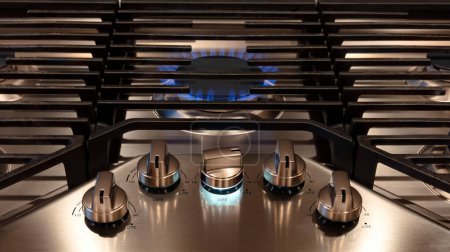 Photo for Modern Kitchen stove top cook with control knobs and metal grills. Gas flame close up on a natural gas stove range burner with metal grill - Royalty Free Image