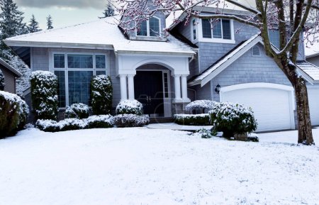 Photo for Snow storm during early spring with home and front yard covered in white snow - Royalty Free Image
