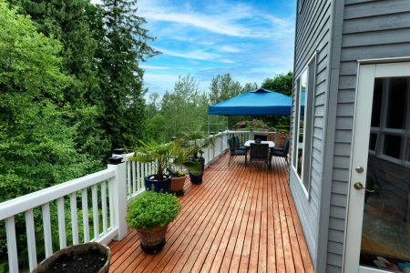 Photo for Walk out home wood deck during spring season with tree and potted plants in bloom - Royalty Free Image