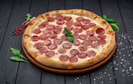 Foto de Pizza casera de queso con salami, deliciosa pizza con cheddar. Comida italiana. - Imagen libre de derechos