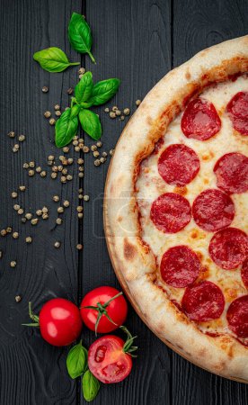 Téléchargez les photos : Pizza pepperoni savoureuse et ingrédients de cuisine tomates basilic Vue de dessus de pizza pepperoni piquante. - en image libre de droit