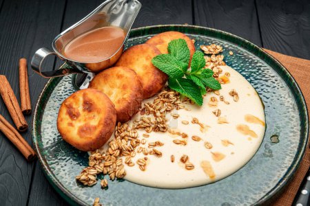 Téléchargez les photos : Homemade Cottage Cheese Pancakes with sweet sauce and granola. Healthy and wholesome food. Serving food in a restaurant. Photo for the menu. - en image libre de droit