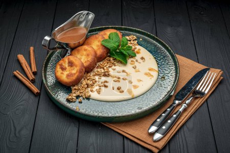 Téléchargez les photos : Homemade Cottage Cheese Pancakes with sweet sauce and granola. Healthy and wholesome food. Serving food in a restaurant. Photo for the menu. - en image libre de droit