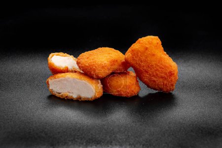 Téléchargez les photos : A pile of chicken nuggets isolated on black color background. Photo for the menu - en image libre de droit