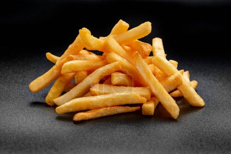 Pile of french fries over black background. Photo for the menu