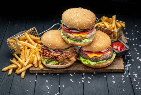 Foto de Set de diferentes hamburguesas con papas fritas. Hamburguesa con pollo, ternera y cerdo ahumado. Foto para el menú - Imagen libre de derechos