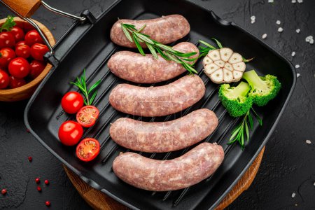Téléchargez les photos : Summer food. Raw homemade sausages with vegetables on a grill pan. - en image libre de droit