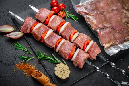 Téléchargez les photos : Vacuum-packed grilled meat, on a dark background. Fresh shashlyk - en image libre de droit