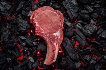 Téléchargez les photos : Raw steak on hot barbecue coals. organic meat - en image libre de droit