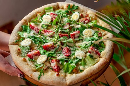 Téléchargez les photos : Pizza maison avec salade César, une portion intéressante de salade avec viande de poulet. Photo de pizza pour menu - en image libre de droit
