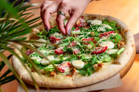 Téléchargez les photos : Pizza maison avec salade César, une portion intéressante de salade avec viande de poulet. Photo de pizza pour menu - en image libre de droit