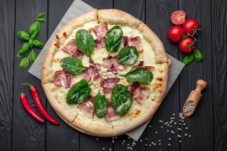 Téléchargez les photos : Grande pizza savoureuse avec bacon et salade fraîche. Vue du dessus de la grande pizza - en image libre de droit