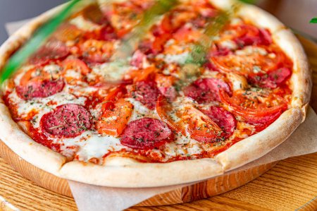 Téléchargez les photos : Pizza pepperoni savoureuse et ingrédients de cuisine tomates basilic Vue d'ensemble de la pizza chaude. - en image libre de droit