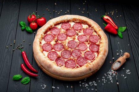 Téléchargez les photos : Pizza pepperoni savoureuse et ingrédients de cuisine tomates basilic Vue de dessus de pizza pepperoni piquante. - en image libre de droit
