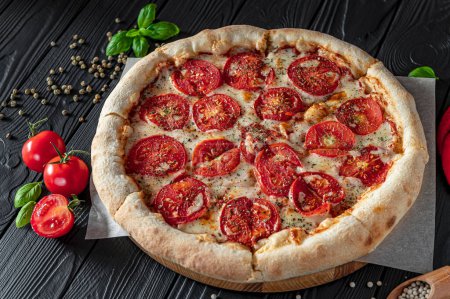 Téléchargez les photos : Pizza Margherita sur fond noir, vue de dessus. Pizza Margarita aux tomates, basilic et fromage mozzarella close up. - en image libre de droit