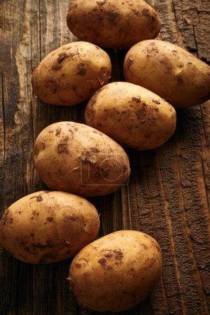 Photo for Potatoes on wooden planks food still life background - Royalty Free Image