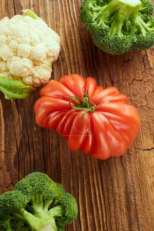 Téléchargez les photos : Food still life with tomato, broccoli and cauliflower on wooden table - en image libre de droit