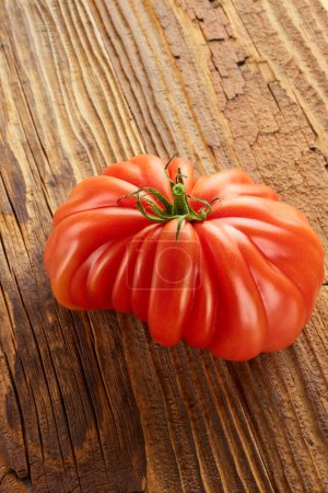 Foto de Fresh ripe tomato vegetable vegetarian food close up on aged wooden texture - Imagen libre de derechos