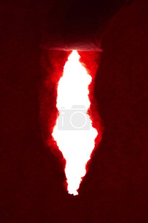 Foto de Papel rojo rasgado con un agujero en el centro del fondo abstracto de la hoja - Imagen libre de derechos