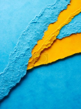 Foto de Hojas de papel rasgadas. Fondo en colores azul y amarillo - Imagen libre de derechos