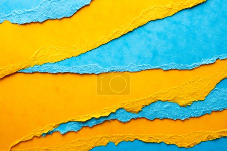 Foto de Hojas de papel rasgadas. Fondo en colores azul y amarillo - Imagen libre de derechos