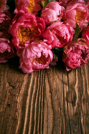 Photo for Peony flowers bouquet over vintage wooden table surface - Royalty Free Image