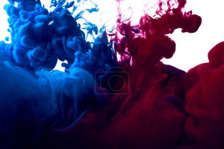 Téléchargez les photos : Des éclaboussures de peintures bleues et rouges dans l'eau sur fond blanc - en image libre de droit