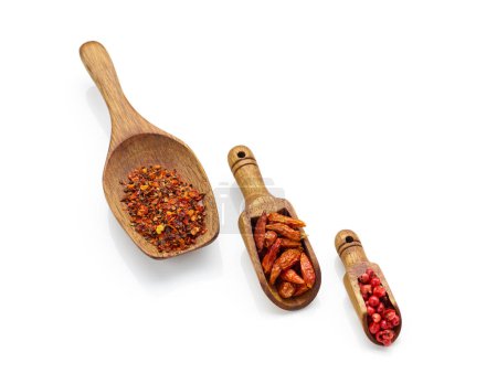 Photo for Chili, peppercorn and crushed pepper in wooden spoons isolated on white background - Royalty Free Image