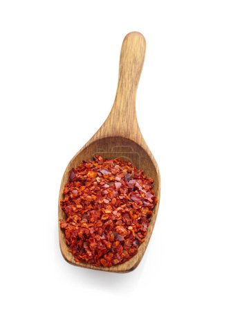 Foto de Pimienta roja triturada en cuchara de madera aislada sobre fondo blanco - Imagen libre de derechos