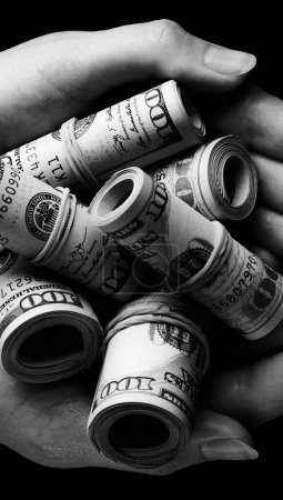 Foto de Cien dólares en efectivo en billetes en manos humanas sobre fondo negro - Imagen libre de derechos