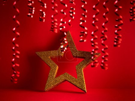 Foto de Feliz Navidad 2024 fondo rojo con estrella dorada y serpentina roja - Imagen libre de derechos