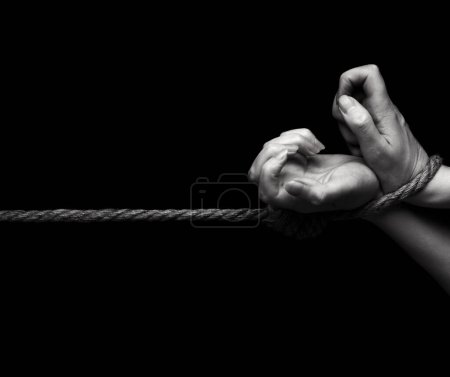 Foto de Mujer manos atadas con una cuerda sobre fondo negro - Imagen libre de derechos