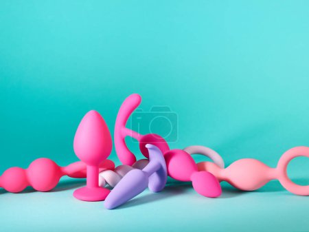 Foto de Montón de juguetes sexuales de silicona sobre fondo turquesa - Imagen libre de derechos