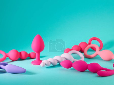 Foto de Conjunto de juguetes plug anal rosa sobre fondo azul turquesa - Imagen libre de derechos