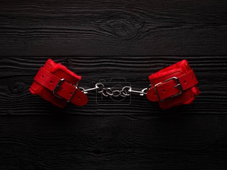Foto de Fondo BDSM con esposas esponjosas de color rojo brillante y cuerda para atar - Imagen libre de derechos