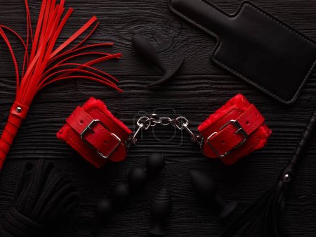 Photo for Adult BDSM toys set over black wooden background - Royalty Free Image