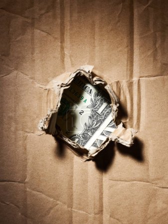 Photo for In hole of cardboard one dollar bills appeared - Royalty Free Image