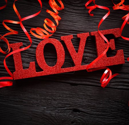 Photo for Red LOVE letters over black wooden background - Royalty Free Image