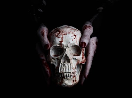 Foto de Manos ensangrentadas sosteniendo cráneo humano sobre fondo negro - Imagen libre de derechos